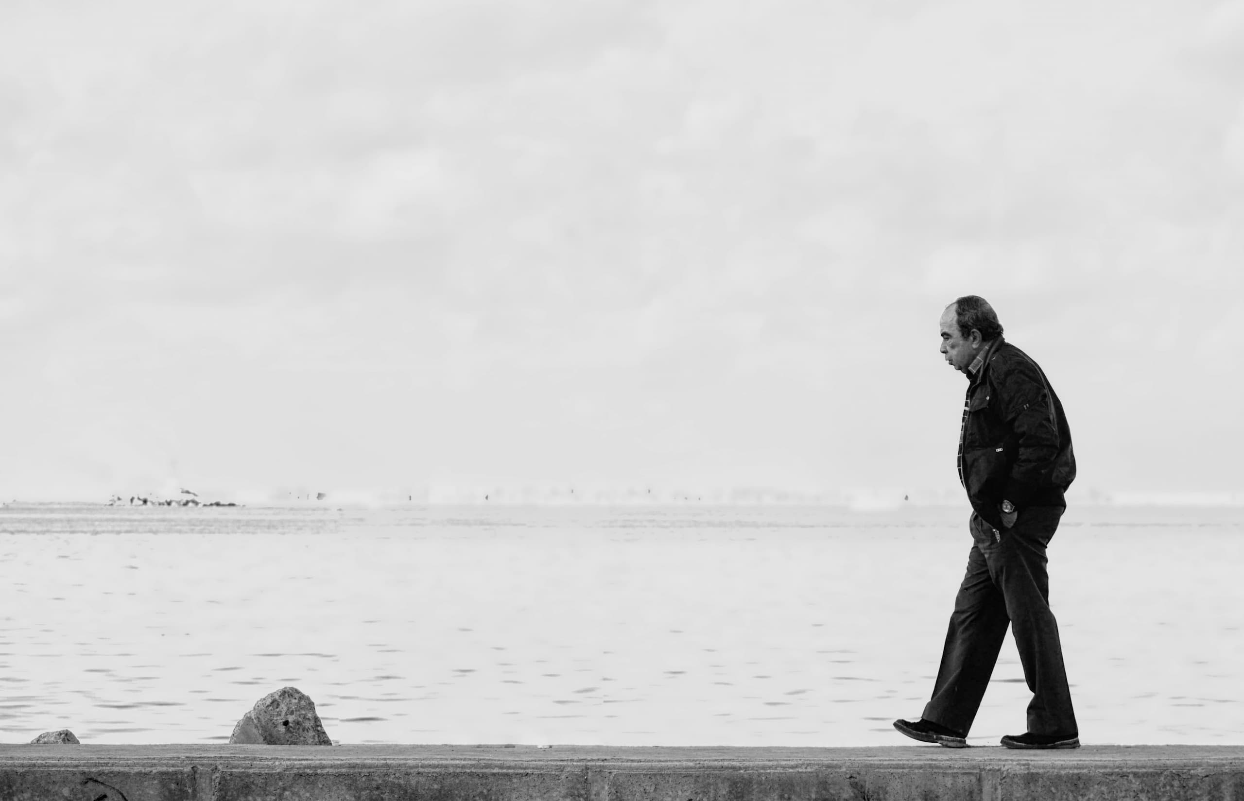 black and white photo of an elderly man walking