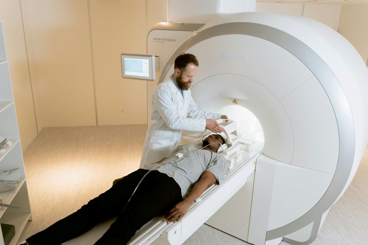 Doctor making final preparations for a patient lying on the CT scan table.
