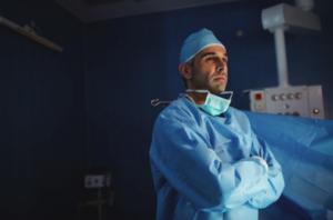 médico urologista em sala de cirurgia pensando sobre a manobra adjuvante em prótese peniana