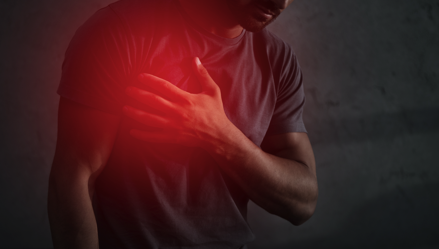 imagem em tom escurecido com homem com a mão no coração e um destaque em vermelho no órgão lembrando doenças cardiovasculares