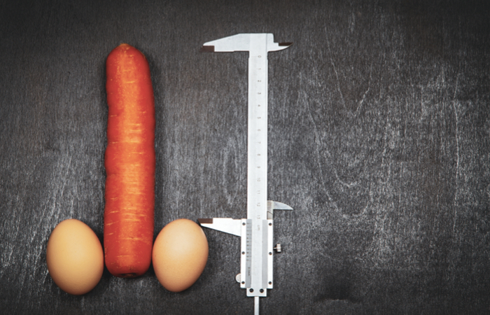 Imagem de uma cenoura e dois ovos representando um pênis, e um medidor ao lado