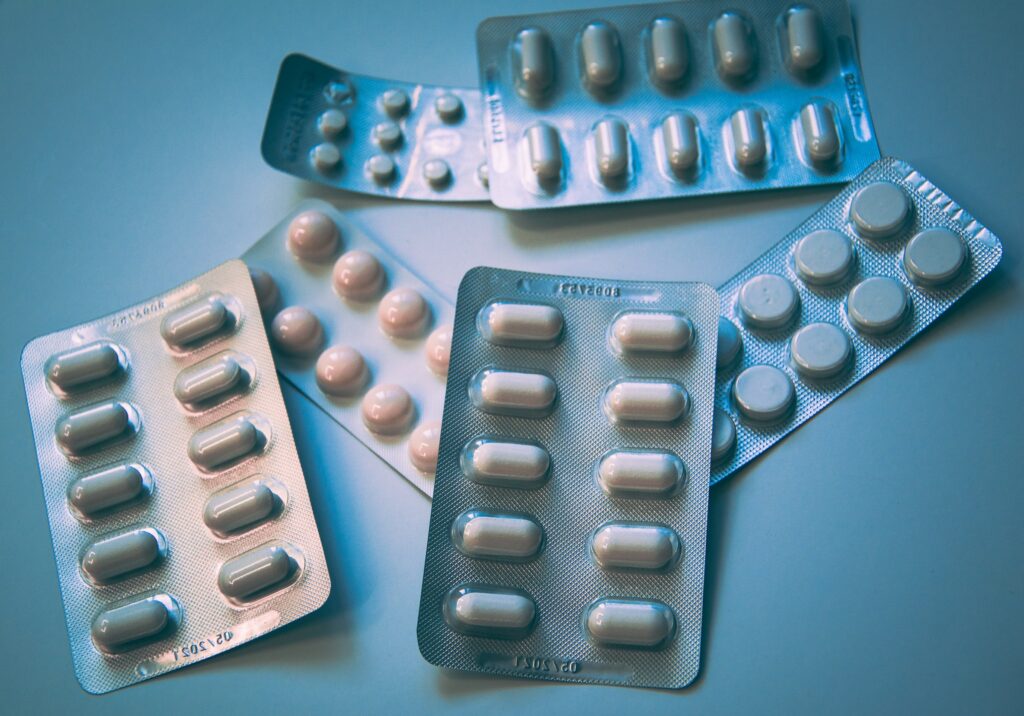 Fundo azul com embalagens de comprimidos de terapia hormonal para disfunção erétil