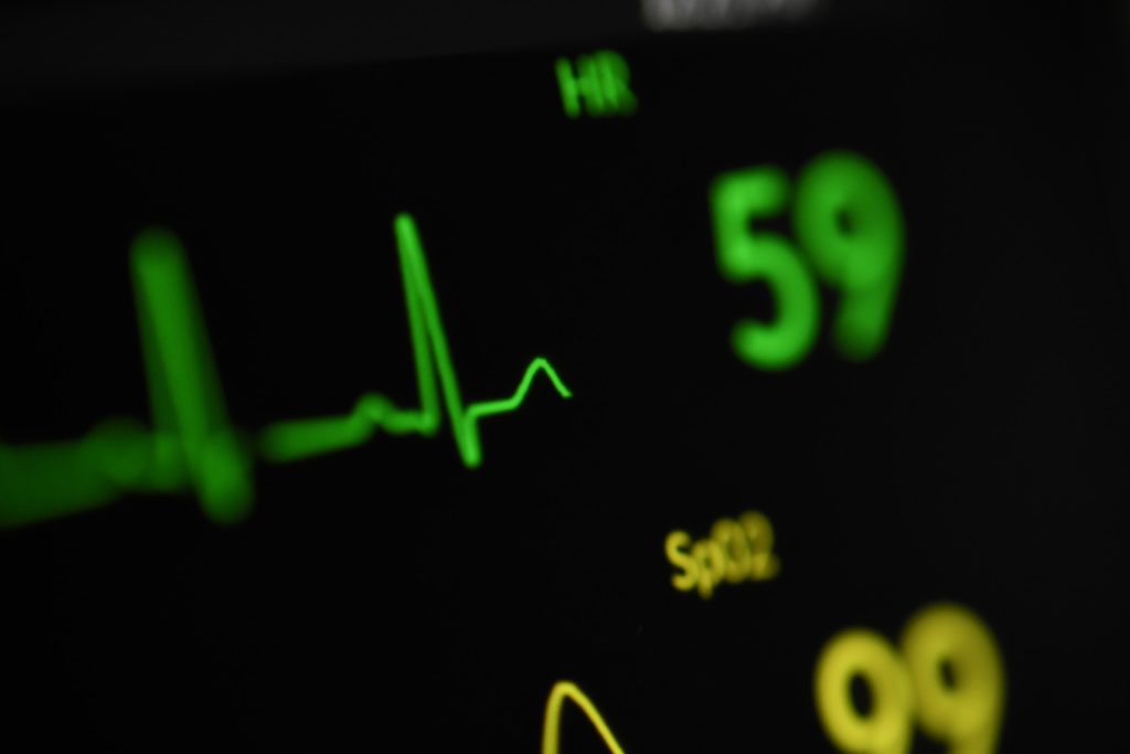 Monitor cardíaco com linhas e números simbolizando um dos problemas de saúde que o atenolol trata e seus impactos na vida sexual masculina