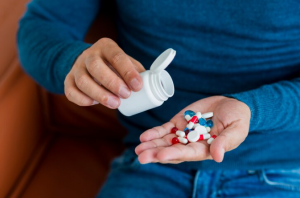 Hidroclorotiazida causa disfunção erétil: homem com um pote de remédio e medicamentos nas mãos.