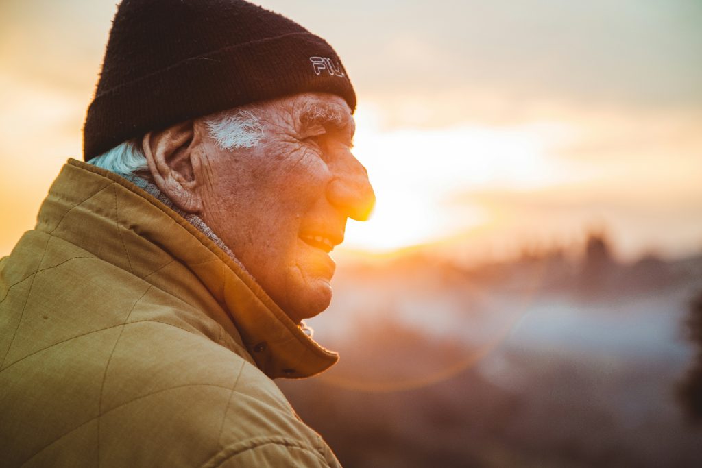 perfil de anciano en primer plano con puesta de sol de fondo representa cambios en la edad que pueden causar el PSA alterado