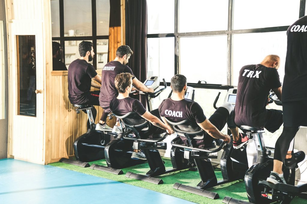 hombres haciendo bicicleta en el gimnasio