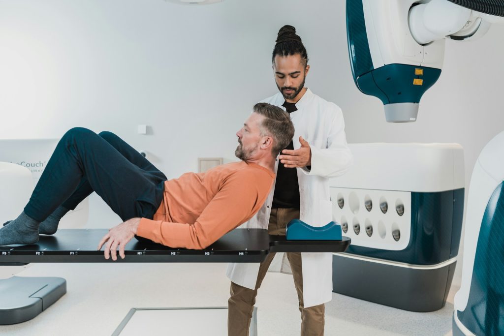 man lying on medical table with the help of a doctor