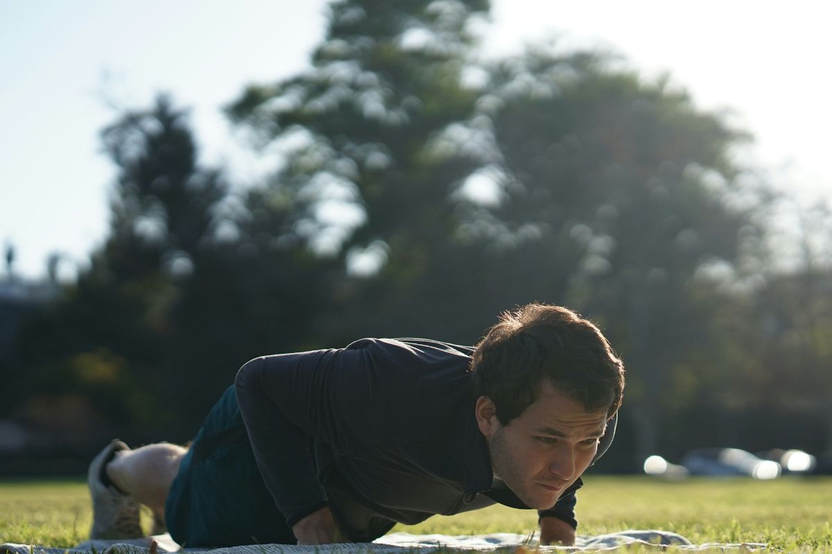 man performing bridge exercise outdoors