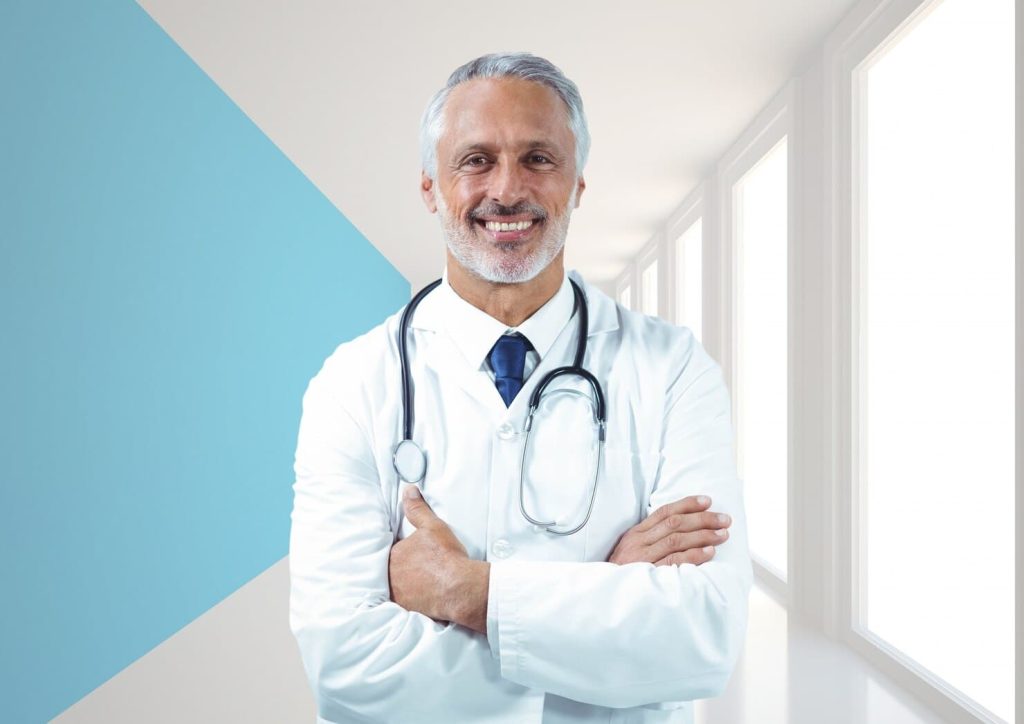 Médico parado em corredor de hospital busca explicar o que causa o priapismo em homens?
