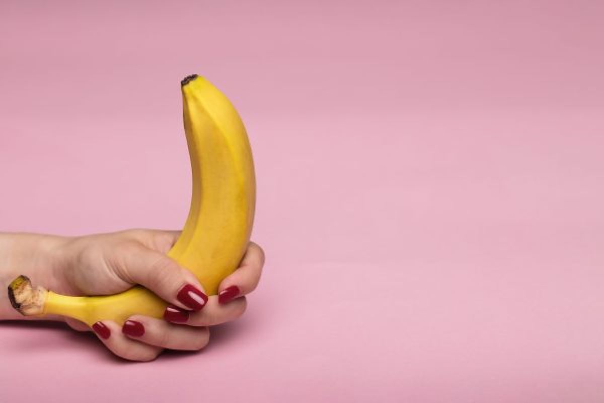 Una mano femenina sosteniendo un plátano