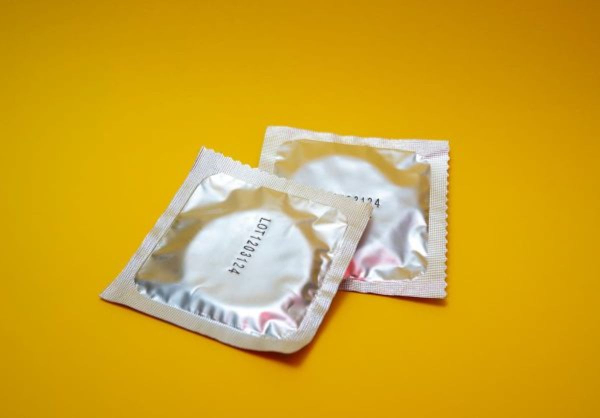 two wrapped condoms on a yellow background