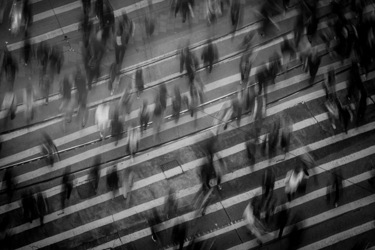A blurred black-and-white photo of people on a crosswalk