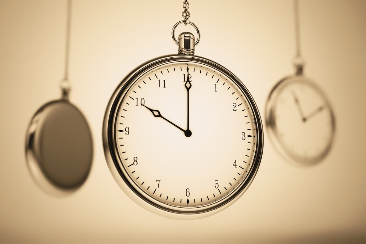 Relógio de bolso dourado em destaque, com dois outros desfocados ao fundo em tom sépia simbolizando se meu marido tem ejaculação precoce