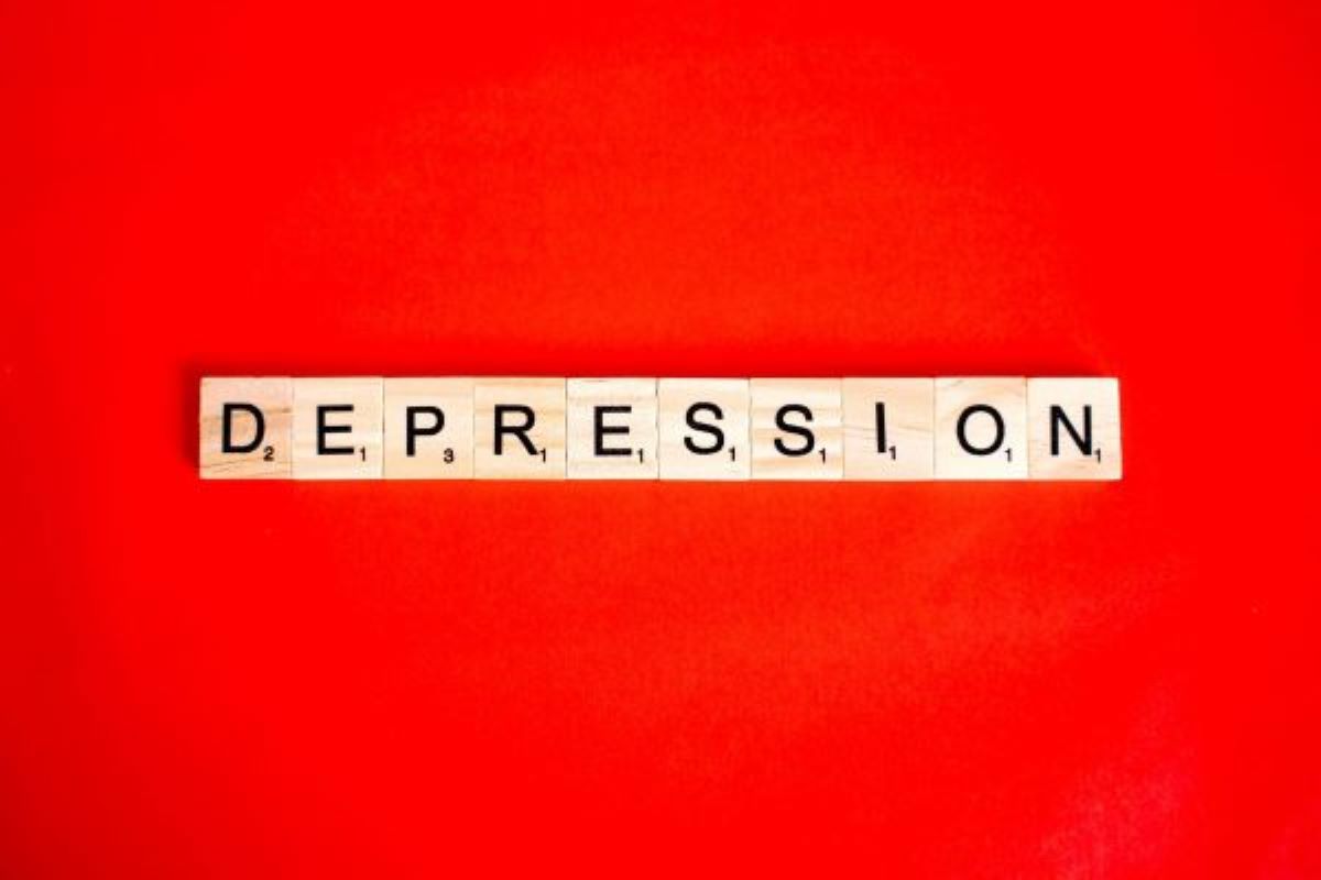 The word “depression” in English on a red background, each letter on a wooden tile.