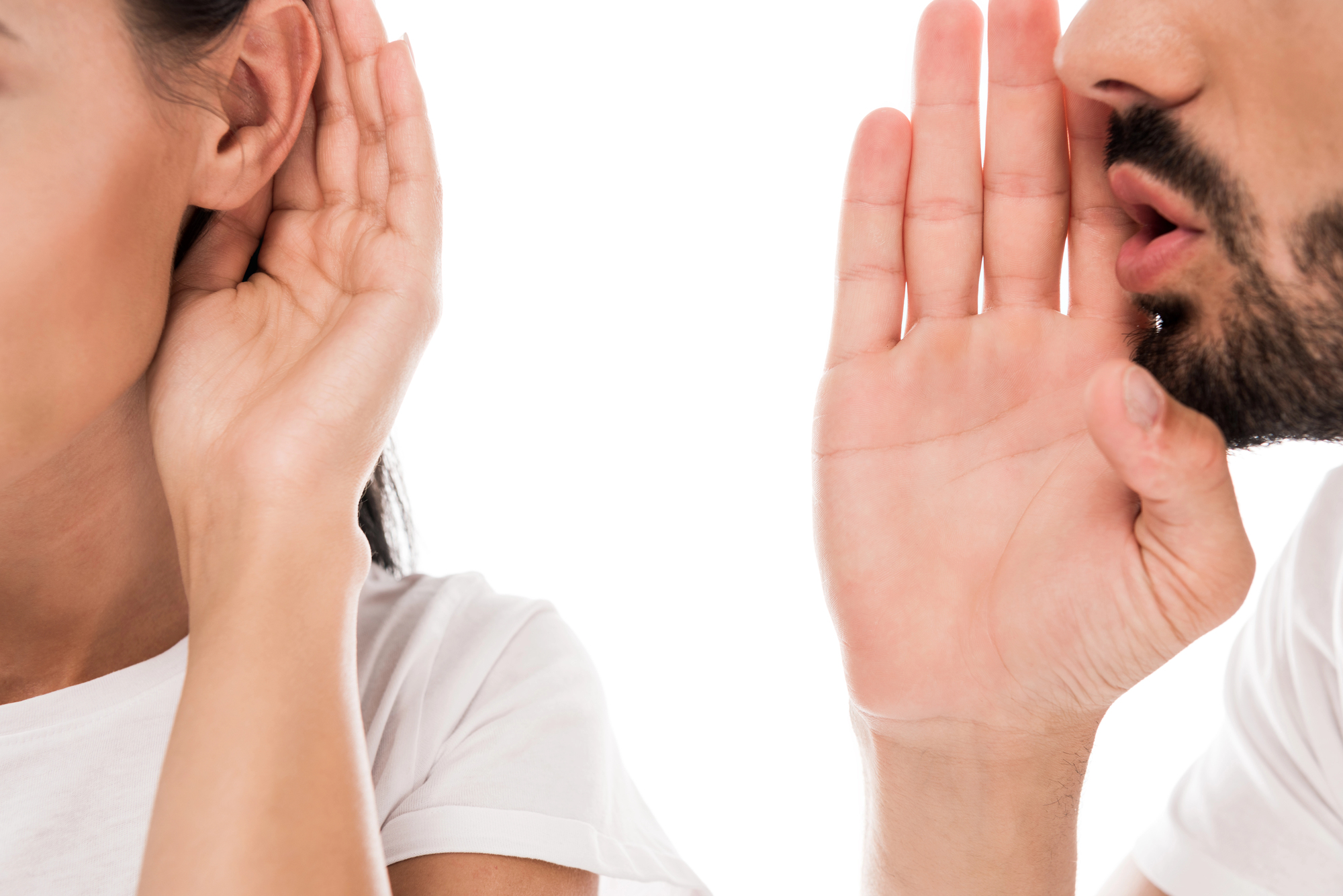 Lateral de um casal branco contra fundo branco, com homem sussurrando como conversar com a parceira sobre problemas sexuais