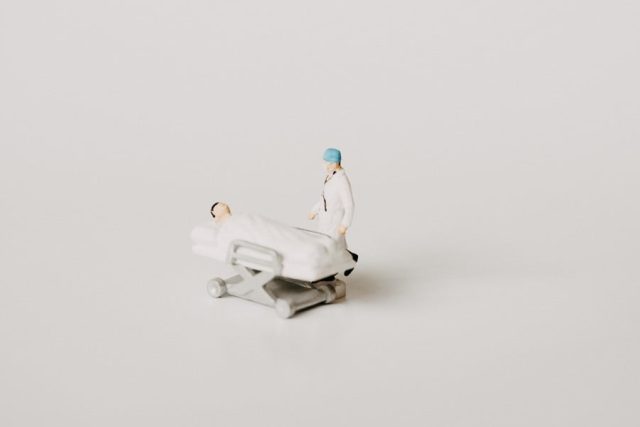 Atrofia peniana: Ilustración de un paciente tumbado en una camilla y el médico a su lado.