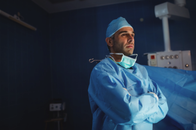 médico urologista em sala de cirurgia pensando sobre a manobra adjuvante em prótese peniana