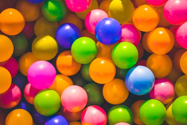 Bolas de plástico de tamanho médio em cores como laranja, rosa, azul e verde simbolizando do